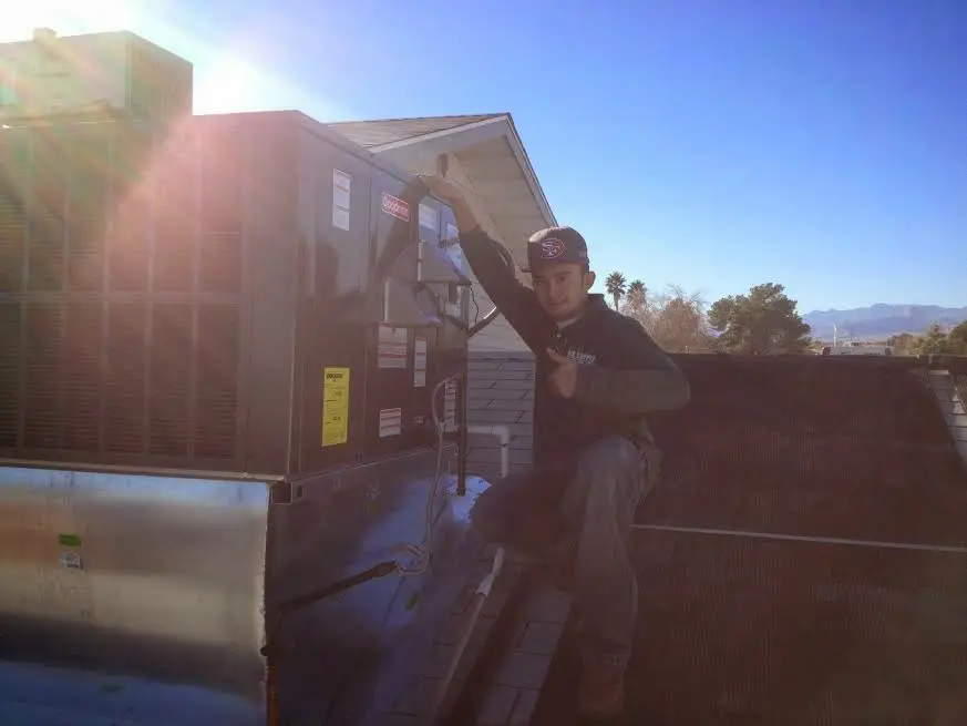 HVAC technician performing AC Tune-Up on a rooftop unit in Brownfield